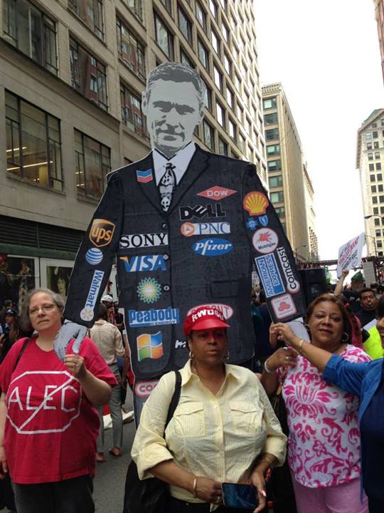 A puppet politician with corporate sponsor logos (Source: Stand Up Chicago)