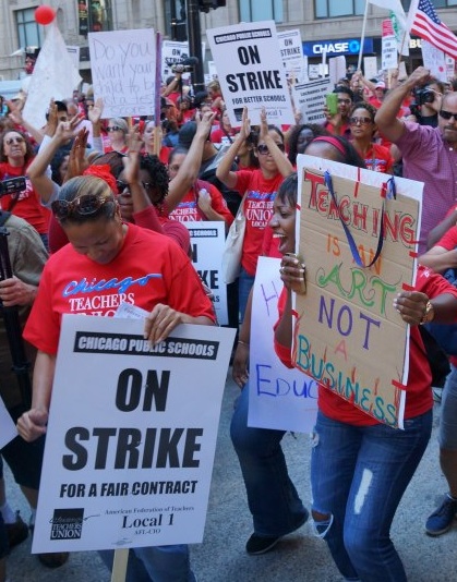 Teachers on strike in Chicago, with sign 'Teaching is an art not a business'