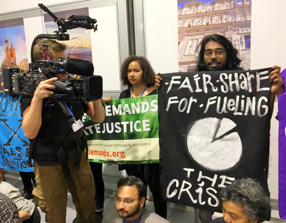 Amalen Sathananthar with his sign, "Fair Share For Fueling The Crisis," which speaks to the fact that the rich countries have caused most of the climate problem, but they refuse to clean up their mess.