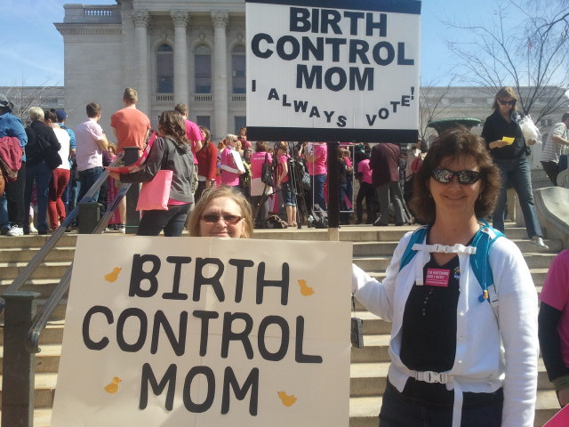 Women holding signs saying "birth control mom"