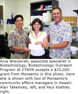  Ania Wieczorek, associate specialist in Biotechnology, accepts a $20,000 grant from Monsanto’s Alan Takemoto, left, and Paul Koehler, right.