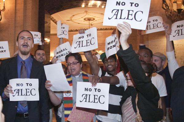 Protestors holding "no to alec" signs