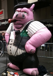 At the Marriott in Times Square, Mark Furlong was met by a towering piggy dressed as a banker.