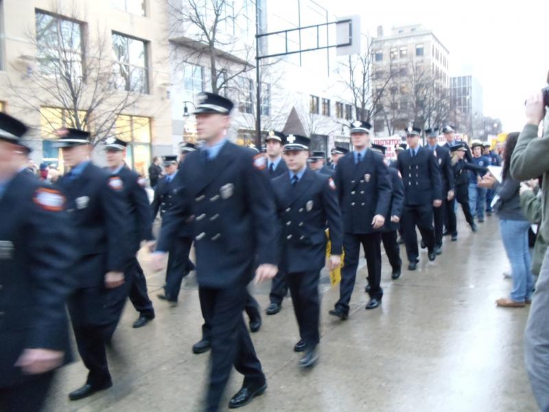 Public safety officials march to a city building.