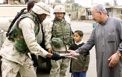 U.S. soldiers distribute the Arabic/English newspaper Baghdad Now. (Photo by Sgt. Mark S. Rickert)