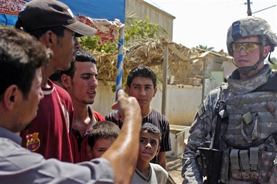 U.S. PsyOps soldier talks with men in Baghdad (Army photo)