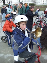 Young cyclist blowing horn